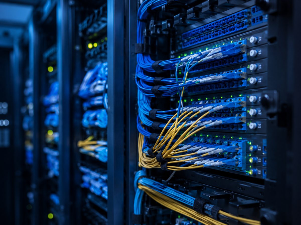Telecom rack room with blue and yellow fiber patch cables