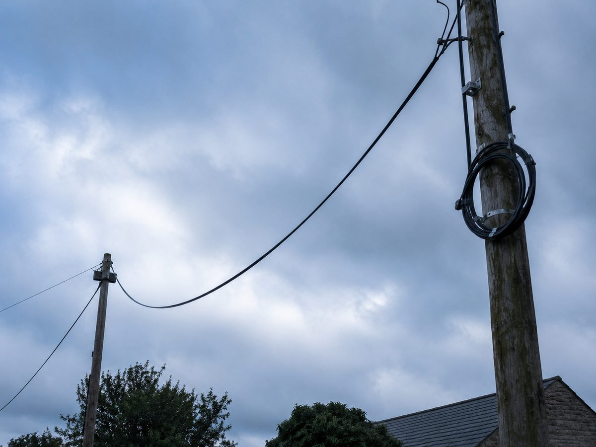 Aerial fiber cable strung between telegraph poles